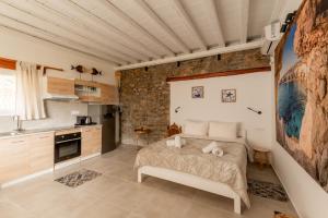 a bedroom with a bed and a stone wall at Honey Bee House in Mikonos