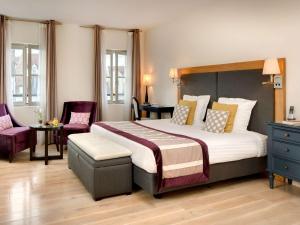 a bedroom with a large bed and two chairs at Hotel Castel Maintenon in Maintenon