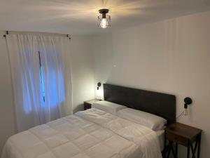 a bedroom with a white bed and a window at La casita Azul in Cazorla