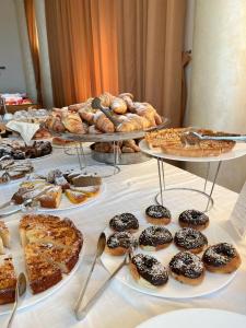 una tavola con diversi vassoi di prodotti da forno e torte di Jonico Hotel a Torre San Giovanni Ugento
