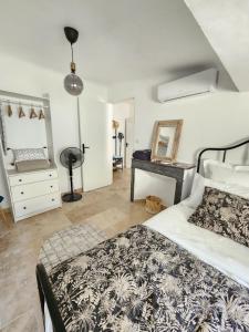um quarto com uma cama e uma cómoda com um espelho em Le Beffroi de Gaston em Aix-en-Provence
