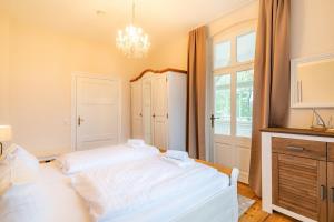 a bedroom with a white bed and a window at Villa Albus App 4 in Ahlbeck
