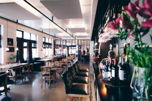 a restaurant with couches and tables and chairs and flowers at Eyja Guldsmeden Hotel in Reykjav&iacute;k