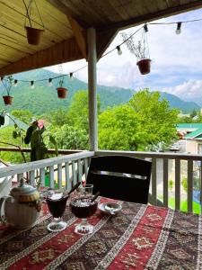 uma mesa com copos de vinho numa varanda com vista em Gabala Boutique Hotel em Gabala