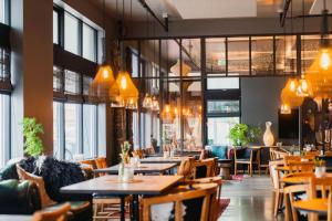 un restaurante con mesas, sillas y ventanas en Eyja Guldsmeden Hotel, en Reikiavik