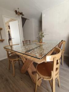 a dining room table with a glass top and chairs at Alojamiento Rural El Cerro in Fresneda de la Sierra