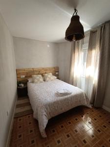 1 dormitorio con 1 cama con edredón blanco en Alojamiento Rural El Cerro, en Fresneda de la Sierra