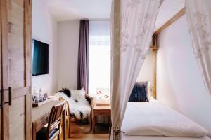 1 dormitorio con mesa, cama y ventana en Eyja Guldsmeden Hotel, en Reikiavik