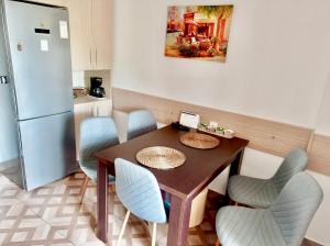 a kitchen with a table and chairs and a refrigerator at Valcea Northside Spacious Apartment in Râmnicu Vâlcea