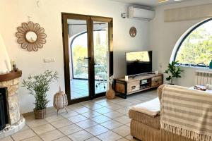 ein Wohnzimmer mit einem TV, einem Sofa und einem Kamin in der Unterkunft Casa Ardilla in Altea
