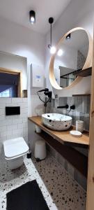 a bathroom with a toilet and a large mirror at Apartamenty Poddąbie1 in Poddąbie +47 photos