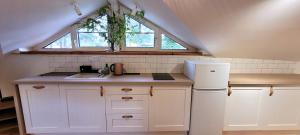 a kitchen with white cabinets and a sink and a window at Apartamenty Poddąbie1 in Poddąbie