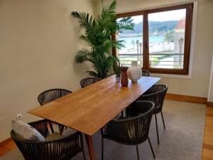 a dining room table with chairs and a large window at PISO DÚPLEX - ISLA DE LA TOJA (O GROVE) in O Grove