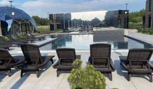 a group of chairs sitting next to a swimming pool at J7 Beržas 7A-1 in Palanga