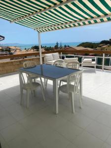 une table bleue et des chaises sur une terrasse dans l'établissement LA TERRAZZA DI MARTA, à Porto Empedocle