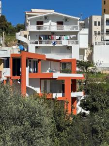 a white and orange building with a balcony at Apartments Olga in Ulcinj