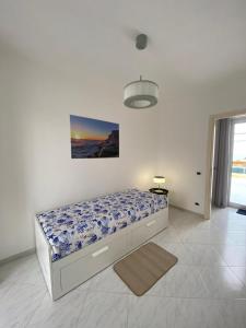 - une chambre avec un lit et une photo sur le mur dans l'établissement LA TERRAZZA DI MARTA, à Porto Empedocle
