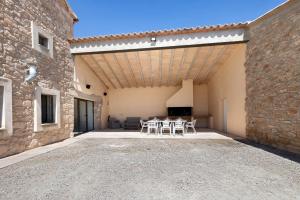 a patio with a table and chairs in a building at Mas Françó in Igualada