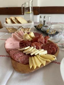 a plate of different types of meats and cheese on a table at Guest House Piatra Craiului in Bran