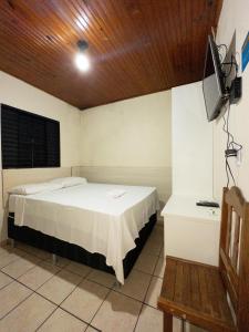 1 dormitorio con 1 cama y TV en Plaza Hotel, en Jataí