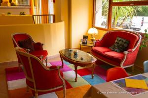 sala de estar con sillas, mesa y sofá en Appart'Hotel Castel Emeraude, Charme et Caractère en Amélie-les-Bains-Palalda