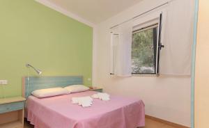 a bedroom with a pink bed with towels on it at Charming Studio in Vieste, 25 m², Shared Pool in Vieste