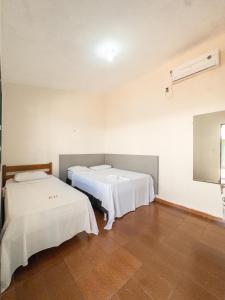 2 camas en una habitación con paredes blancas en Plaza Hotel, en Jataí