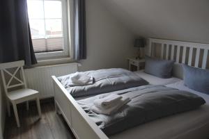 a bedroom with two beds and a chair and a window at REGIOHOTEL Aparthotel Wernigerode in Wernigerode