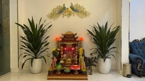 a altar in a room with two potted plants at Royal Hotel Vĩnh Phúc in Vĩnh Phúc