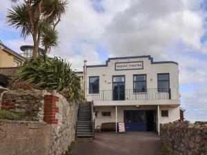 a white building with a palm tree in front of it at 16 Church Street in Lyme Regis