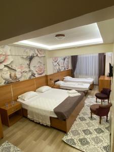 a bedroom with two beds and a painting on the wall at İHVA HOTEL PİERRELOTİ in Istanbul