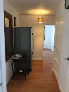 einen Flur mit einem Kühlschrank und einem Tisch in einem Zimmer in der Unterkunft 2or3 double bedrooms apartment free parking in Edinburgh