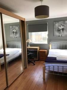 1 Schlafzimmer mit 2 Betten, einem Schreibtisch und einem Spiegel in der Unterkunft 2or3 double bedrooms apartment free parking in Edinburgh