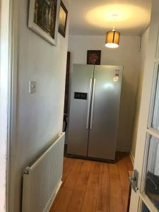 einen Kühlschrank in einem Zimmer mit Holzboden in der Unterkunft 2or3 double bedrooms apartment free parking in Edinburgh