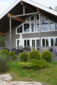 una casa con un patio con una sombrilla delante de ella en Utsikten - Ny flott hytte, Privat Badstue, Spabad!, en Torsby