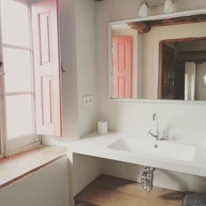 een badkamer met een witte wastafel en een spiegel bij La Madrigata al completo in Revilla de Cepeda
