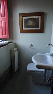 een badkamer met een wit toilet en een wastafel bij La Madrigata al completo in Revilla de Cepeda