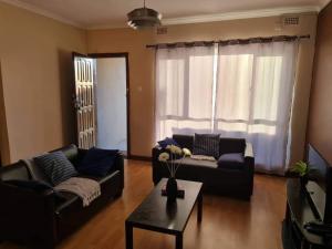 a living room with two couches and a coffee table at Lake road Apartment in Lusaka