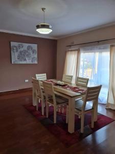 a dining room with a wooden table and chairs at Lake road Apartment in Lusaka