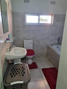 a bathroom with a sink and a toilet and a tub at Lake road Apartment in Lusaka