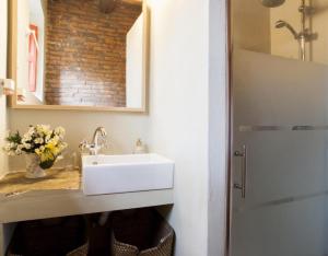 La salle de bains est pourvue d'un lavabo blanc et d'un miroir. dans l'établissement Apartamento Azul, à Revilla de Cepeda