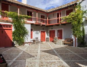 une cour d'une maison avec des portes rouges dans l'établissement Apartamento Azul, à Revilla de Cepeda
