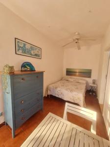 a bedroom with a bed and a blue dresser at Le Case dei Pescatori - Casetta Faraglioni in Ponza