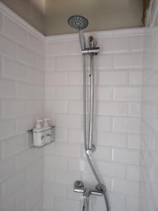 een douche in een badkamer met witte tegels bij Casa Grande in Revilla de Cepeda