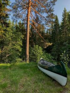 una canoa sentada en el césped en un campo en Utsikten - Ny flott hytte, Privat Badstue, Spabad!, en Torsby
