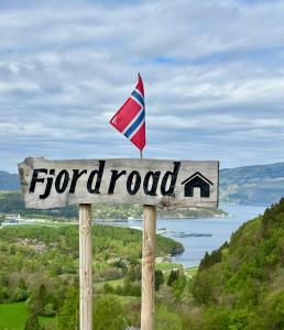 a sign with a flag on top of a road at Fjord road in Hjelmeland