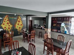 um restaurante com mesas e cadeiras e uma parede de pizza em Pousada Espaco Verde em Itarema