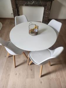 una mesa blanca y sillas con una cesta. en Chambre disponible en Bruselas