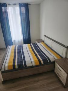 1 cama con edredón a rayas en un dormitorio en Chambre disponible en Bruselas