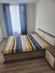 a bedroom with a bed with a striped comforter at Chambre disponible in Brussels